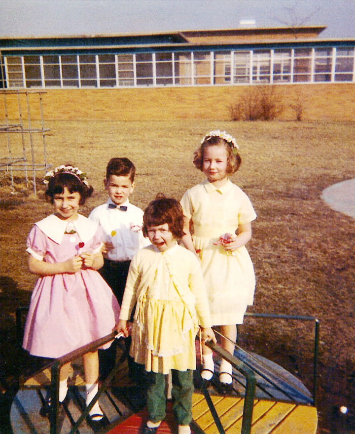 Children pose in the play yard of the Barbara Givernaud Cottage at St. Joseph's Village